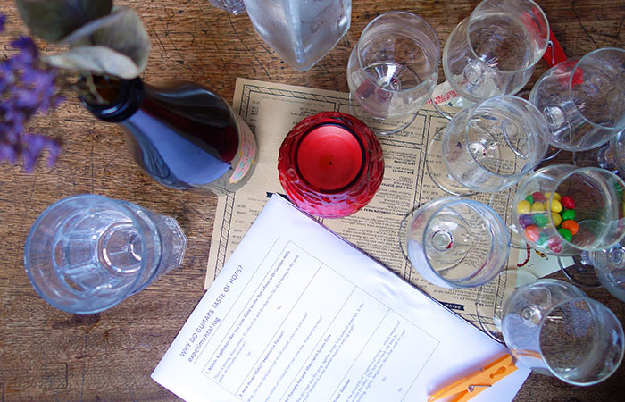 Glasses, bottles, and worksheets on a table, photographed from above