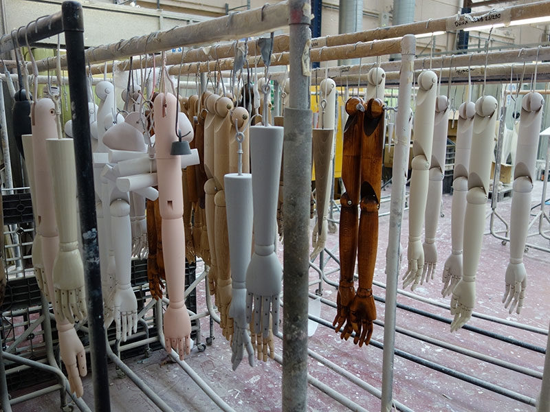 A batch of mannequin arms hanging on a rack