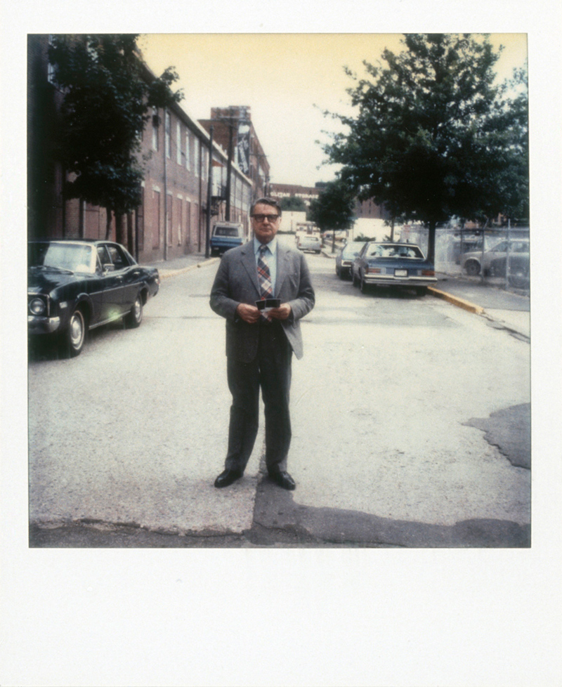 A Polaroid photo of Edwin Land standing in the middle of the street