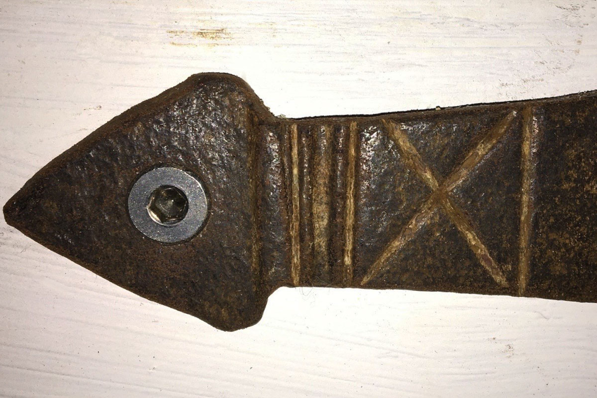 Lines and a cross carved into an iron strap