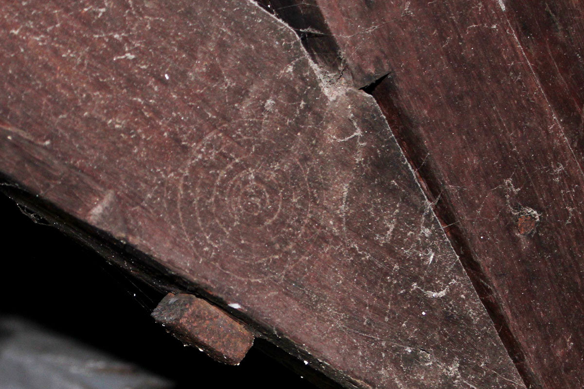 Circles carved imto a wooden beam