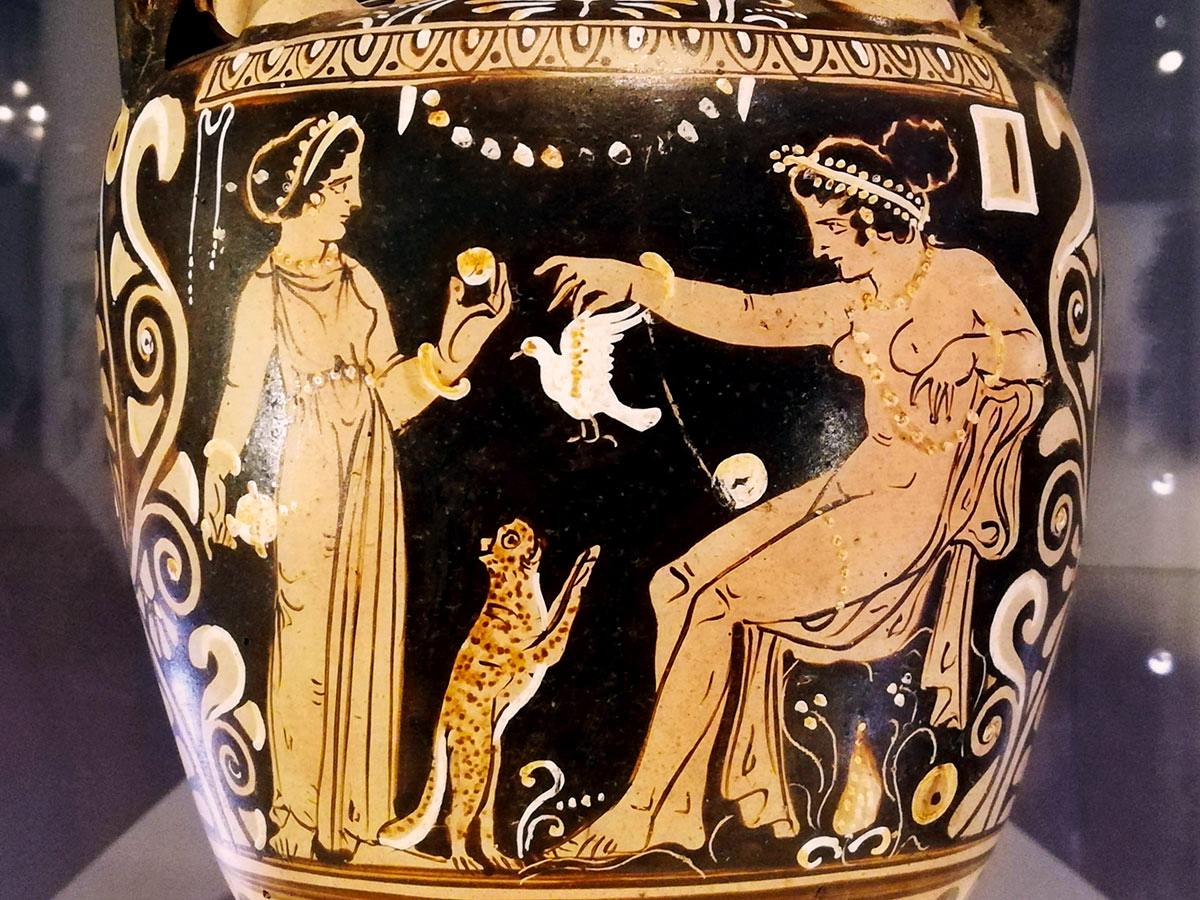 Close-up of an ancient black and orange pot, including a car begging for a bird