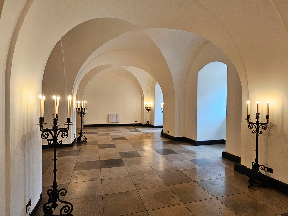 A room with vaulted ceilings and standing candleabras