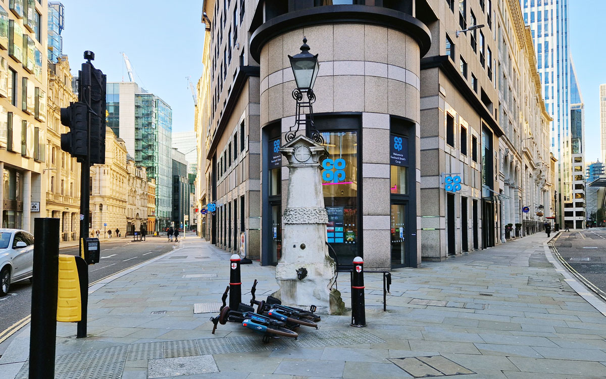 A light and water fountain in the footpath at the point two streets split off