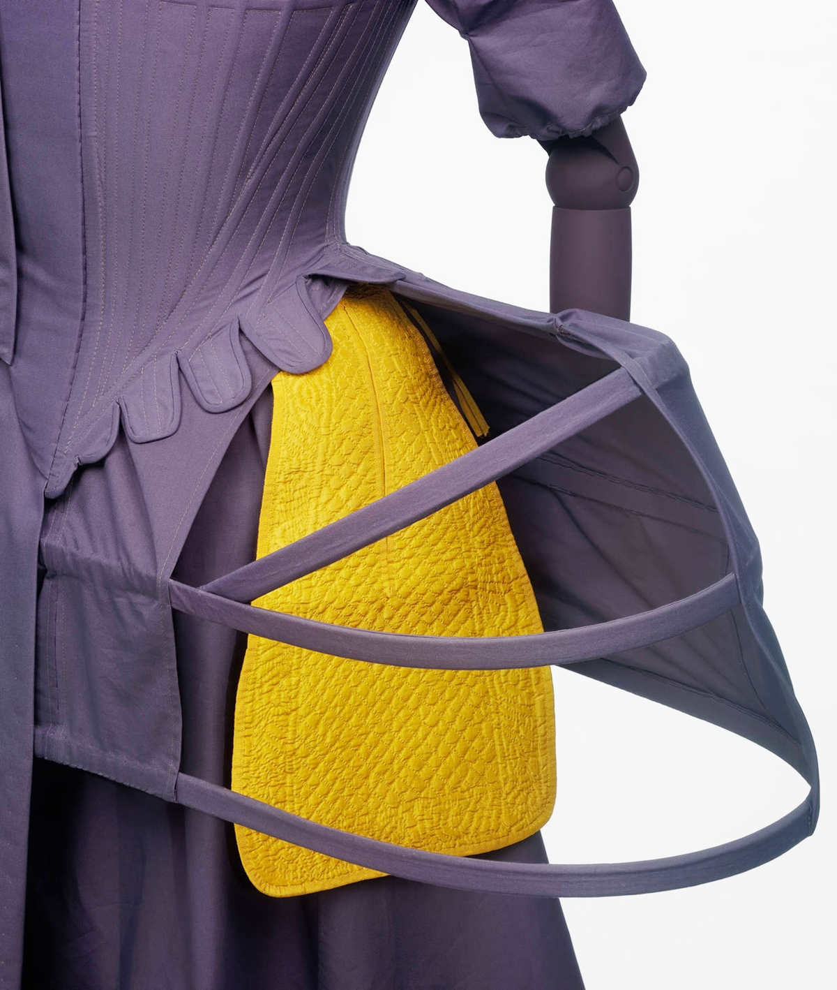 A close-up of the under-garment support structure of an 18th Century dress with a tied-on pocket around the waist